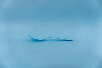 minimal photo of a blue spoon in a blue background