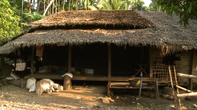 Medium low-angle front-view still shot of a wide traditional house at a remote village in Shan State, Myanmar