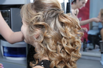 Blonde with long hair in a beauty salon at the makeup artist