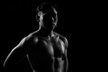 Fototapeta na wymiar Asian Big Muscle Fitness Man exercise show arms, bicep, chest with sweat from heat. Young Sport Male six packs shoot in low key lighting exposure with shadow contrast, copy space