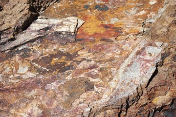 Colorful closeup detail of rough stone boulder horizontal background texture