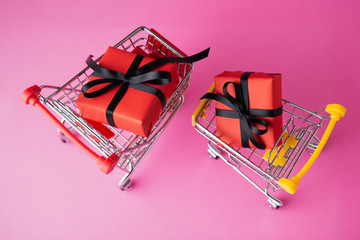 Red gift box with black bow in shopping carts