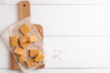 Fresh caramel fudge candies on white rustic background