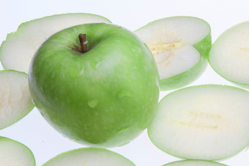 Close up of the green apple with drops and slices