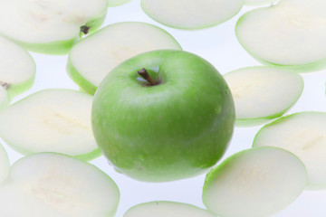 Close up of the green apple with drops and slices