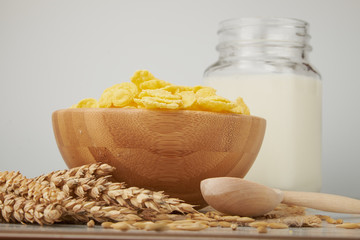 Bowl with Cornflakes and Milk on an wooden table
