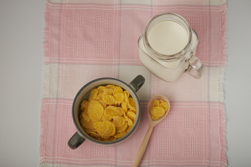 Bowl with Cornflakes and Milk on an wooden table
