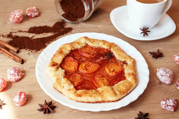 Apricot pie with coffee on kitchen table. Summer berry biscuit recipe.