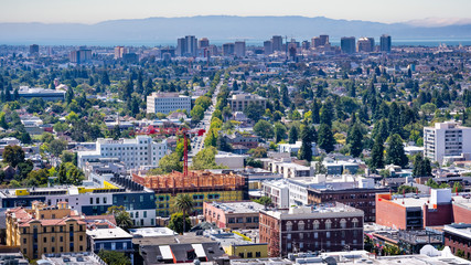 Aerial view of Berkeley and north Oakland on a sunny day; downtown Oakland in the background;...
