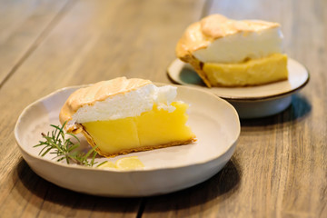 Piece of lemon meringue pie on wooden table