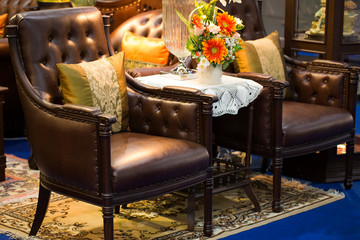 The pillow is leaning on a leather chair as a beautiful backdrop.