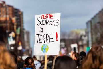 French sign held at ecological protest. A French sign is viewed close-up above the heads of...