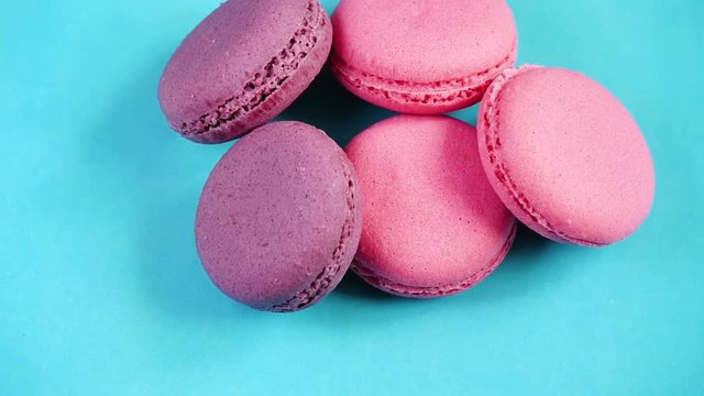 Colorful cookies or French macaroon dessert on pastel background.