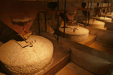 Interior of windmill or watermill, Stone grinder used for making flour