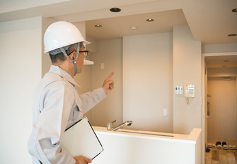 ヘルメットのビジネスマン　住宅リフォーム　汎用　メモ　キッチンまわり　指差し