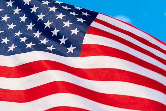American flag waving in the wind against blue sky