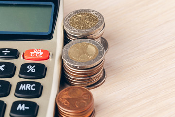 Close up of a calculator and coins on a business background
