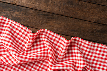 Red checkered tablecloth on wooden background