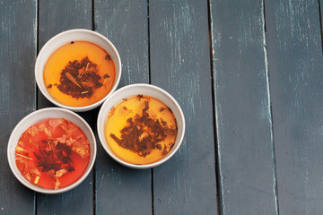 Tea concept. Different kinds of dry tea in ceramic bowls and cups of aromatic tea
