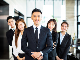 confident asian business team stands in office