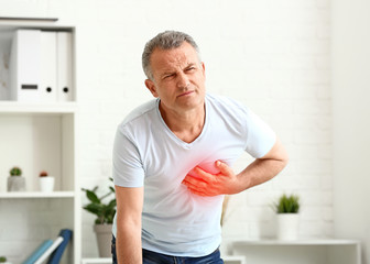 Mature man suffering from heart attack at home