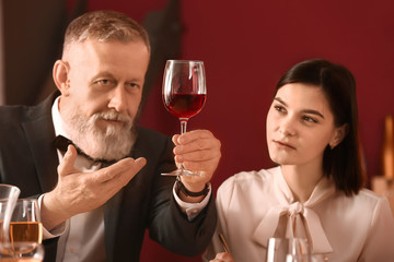 Mature sommelier with his student in wine cellar