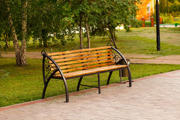 Beautiful wooden bench in the Park. A relaxing evening with family in the Park.