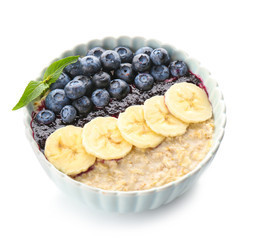 Bowl with tasty oat porridge, blueberry and banana on white background
