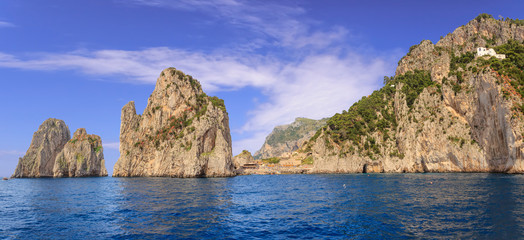  Three famous Faraglioni Rocks in the Bay of Naples on the coast of the Capri Island, Italy. Capri stacks, the symbol of the island, located in the gulf of Naples, Campania.