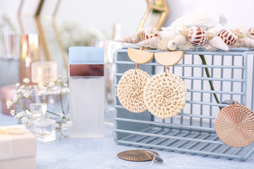 Basket with stylish earrings on dressing table
