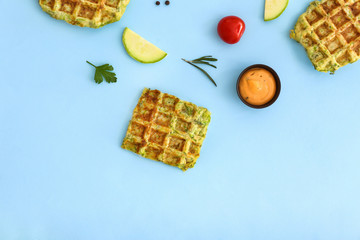Tasty squash waffles with sauce on color background
