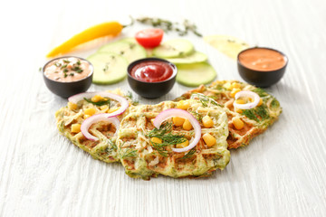 Tasty squash waffles with sauces on white table