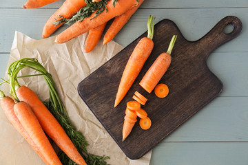Cutting board with fresh carrots on table