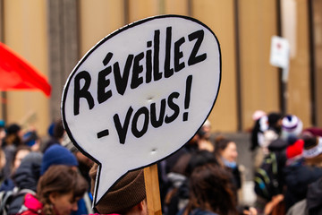 Homemade sign at environmental rally. A French sign is viewed closeup, saying wake up, during a city demonstration held by environmental activists, marching against climate change