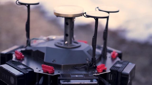 Close up for hands performing assembly of the device for quadcopter filming, modern technologies concept. Clip. Preparation of space orientation system for drone.