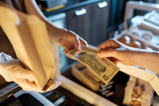 Man paying for a pie in coffee shop with dollars.