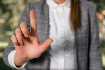 Obraz premium Business woman in the nature pointing with the finger into empty space. Copy space with business woman.