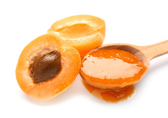 Spoon with tasty apricot jam on white background, closeup