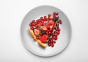 Plate with piece of tasty chocolate strawberry cake on white background