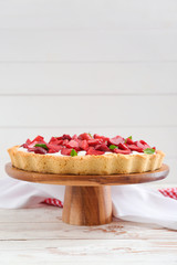 Tasty strawberry cake on white wooden table