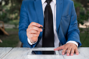 Businessman holds pen and points into copy space.