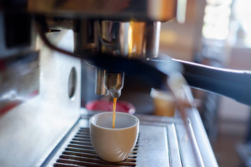 Espresso machine making fresh coffee in small coffee shop