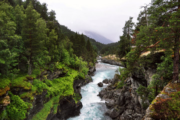 Fototapeta na wymiar Norwegian turbulent mountain river in blue color
