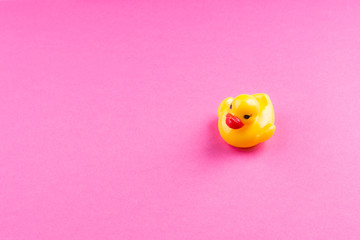 Yellow glamour rubber duck with red lips on pink background.