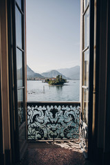 Beautiful view from balcony window at Lago Maggiore and Borromean Islands in sunny light, exploring Italy. Old architecture monuments in Stresa. Summer vacation in Europe