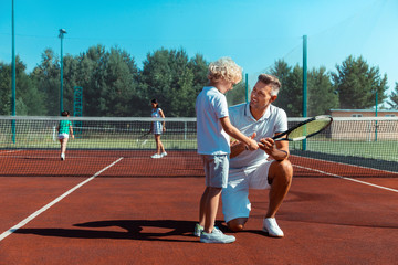 Fototapeta premium Happy father smiling while enjoying weekend with his son