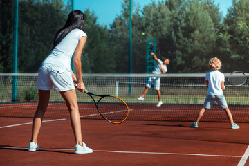 Obraz premium Dark-haired wife playing tennis with husband and son