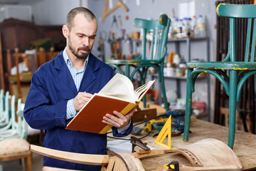 Restorer holding album  at woodwork studio
