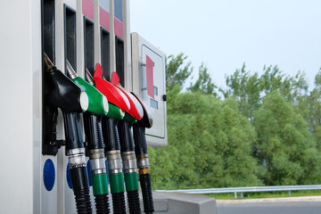 Gasoline and oil products concept. Red and black fuel pistols on fuel station.To fill car with petrol. Close up.