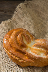 Bun sprinkled with sugar. Sweet pastries. Rustic style